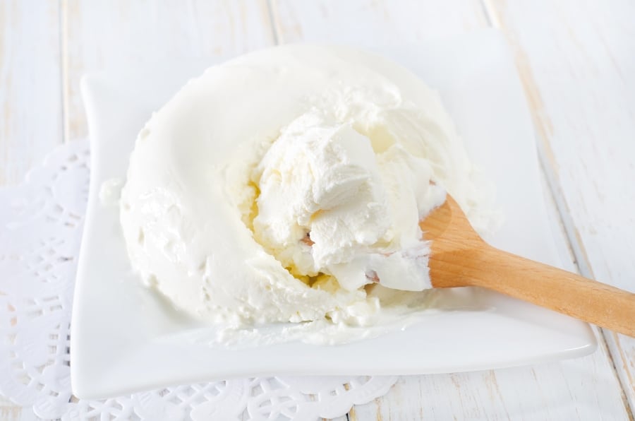 mascarpone being scooped with wooden spoon