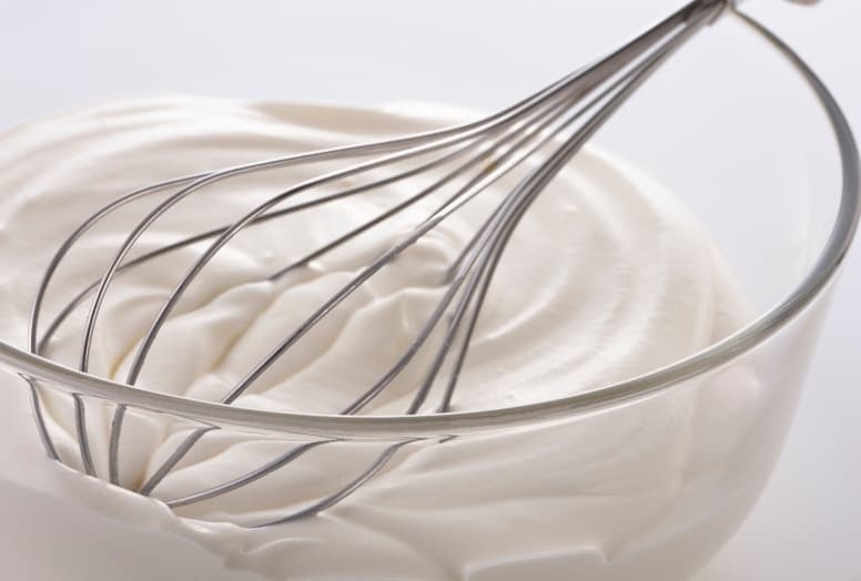heavy whipping cream with whisk in bowl