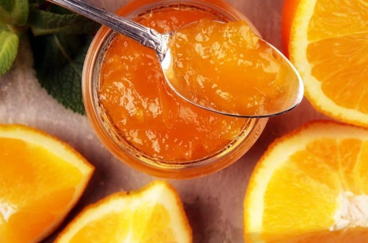 glass jar and spoon of orange marmalade