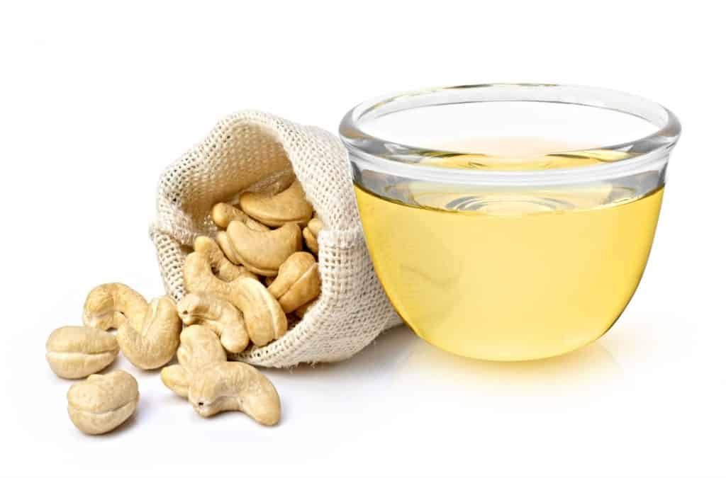 container of cashew extract with a bag of whole cashews