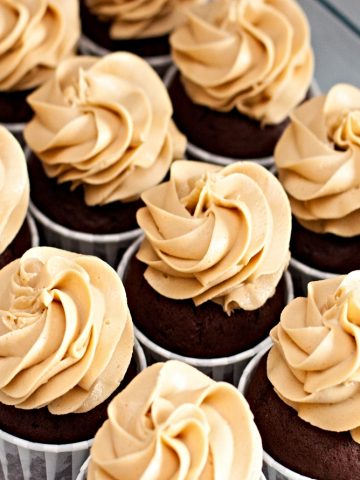 closeup of a dozen chocolate cupcakes with peanut butter frosting