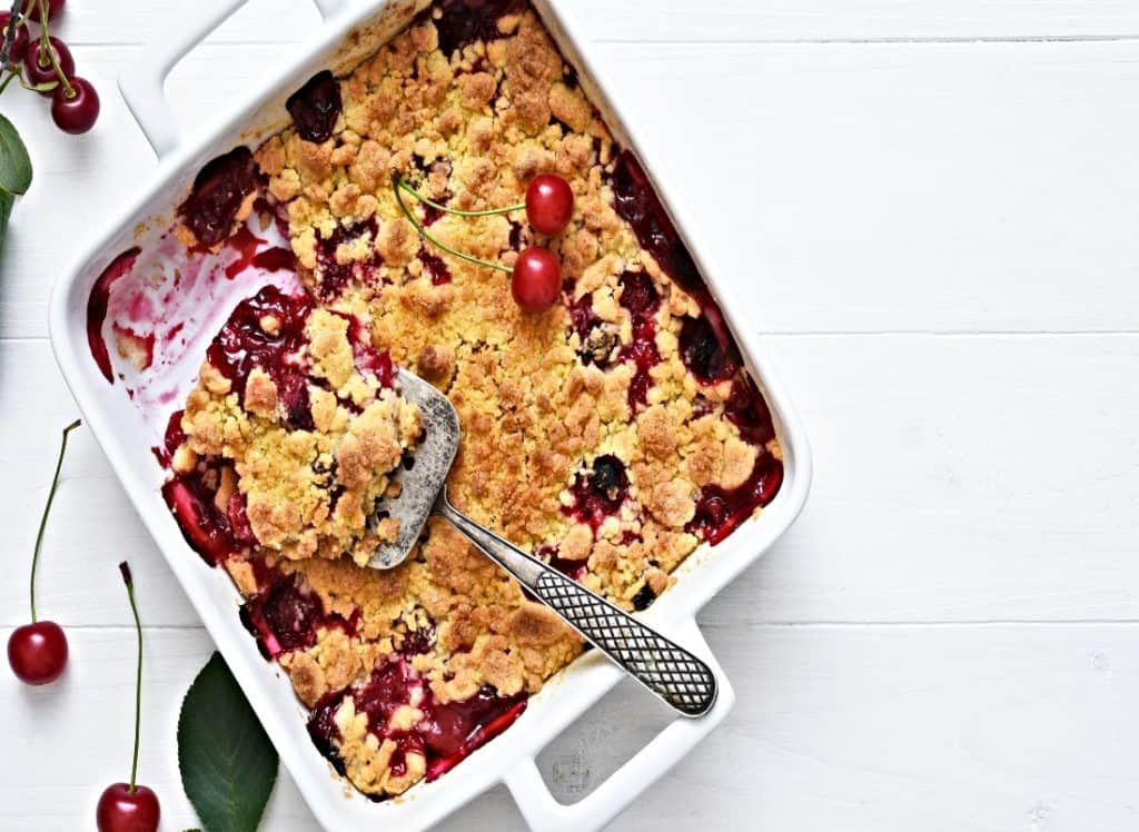baking dish with homemade cherry cobbler with Bisquick top on table viewed from above