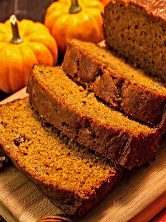 sliced fresh baked loaf of old fashioned pumpkin bread on cutting board on table in dining room